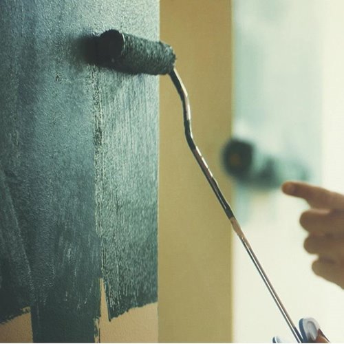 Applying darker green rustic paint to interior walls