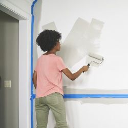 Lady applying interior paint with roller