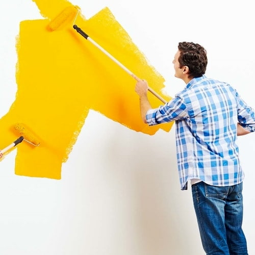 Applying yellow paint to wall