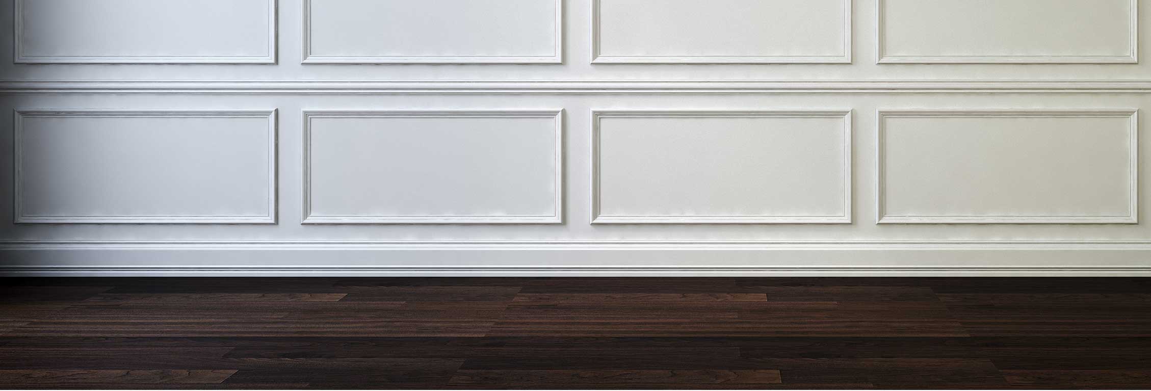 Zoom of molding of white decorative wall with dark brown wooden flooring