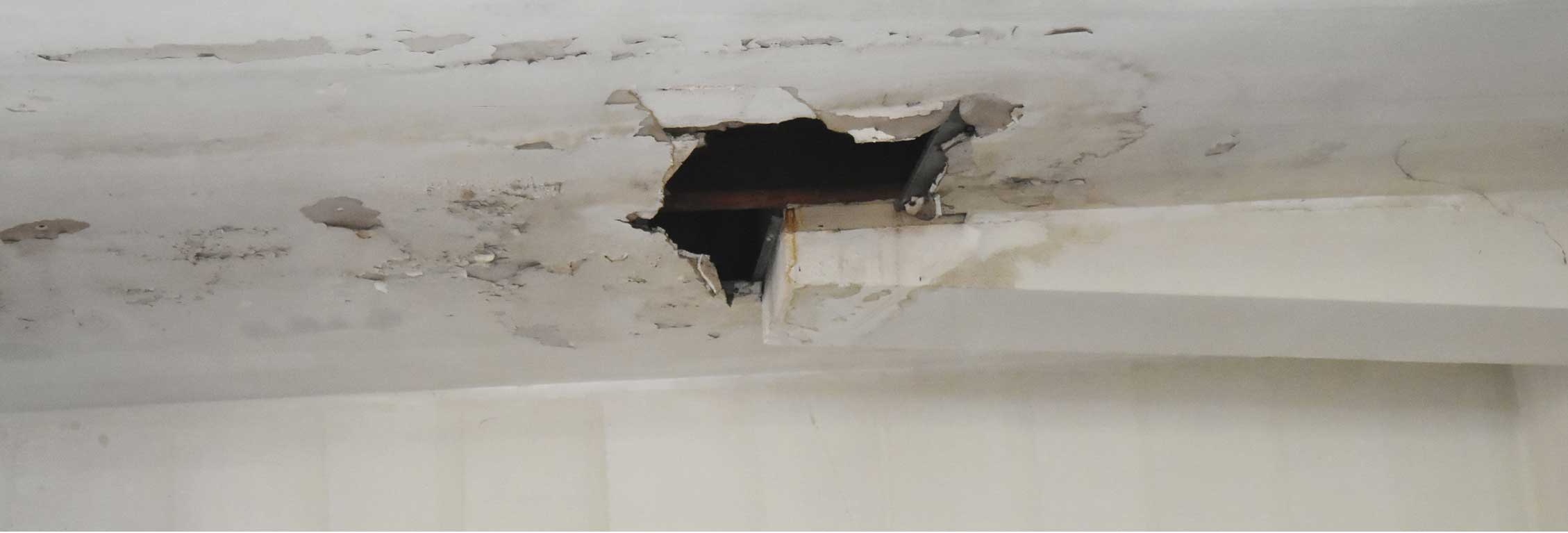 Worn white ceiling with hole 