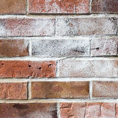 White paint residue on red brick wall