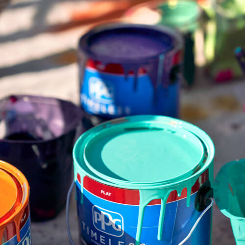 PPG paint buckets with bright cyan in front and orange, purple and green in foreground and background
