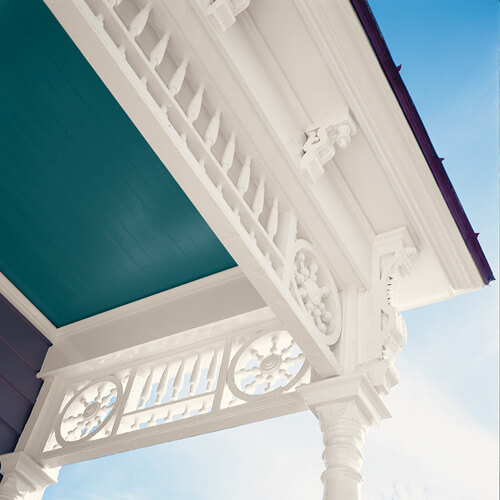 Angle of outside underroof with teal ceiling and decorative white framing
