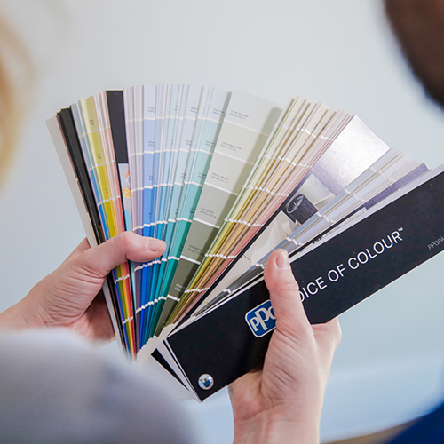 Person's hands holding and spreading out color gradient swatches